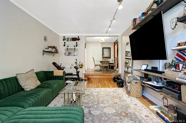 a view of a hallway with wooden floor and a bathroom