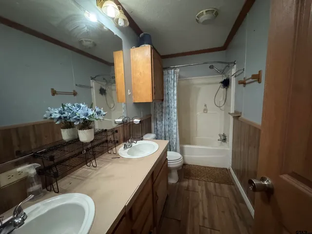 a bathroom with a double vanity sink mirror and shower
