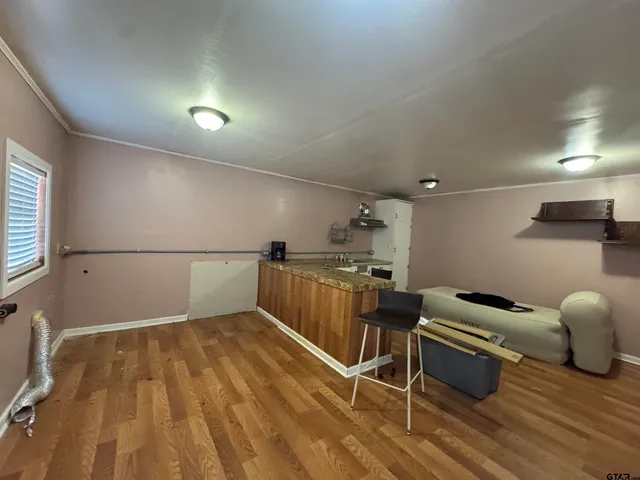 a hallway with a white cabinets wooden floor and a couch
