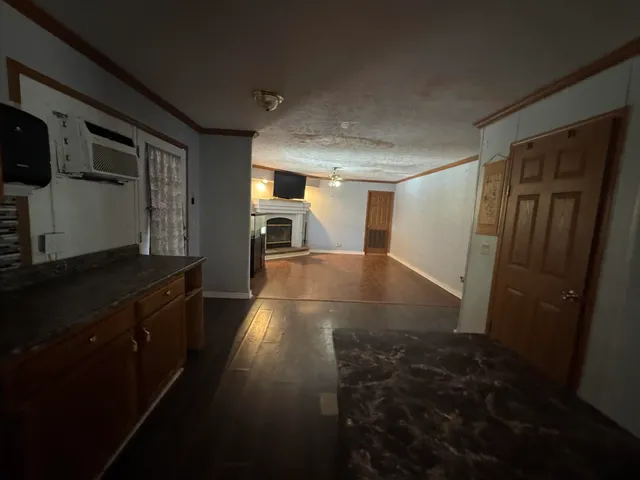 a view of hallway with wooden floor and cabinets