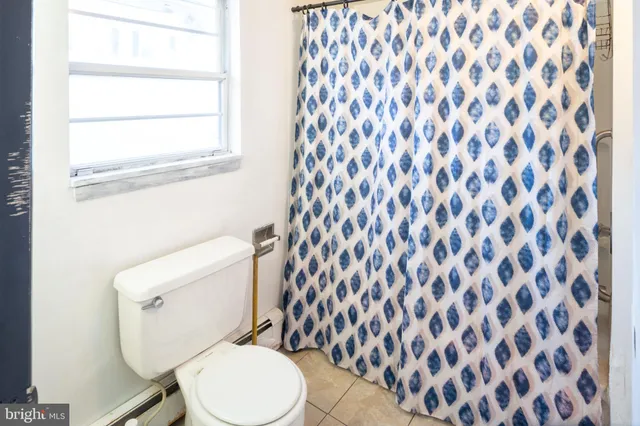 a white toilet sitting next to a shower curtain