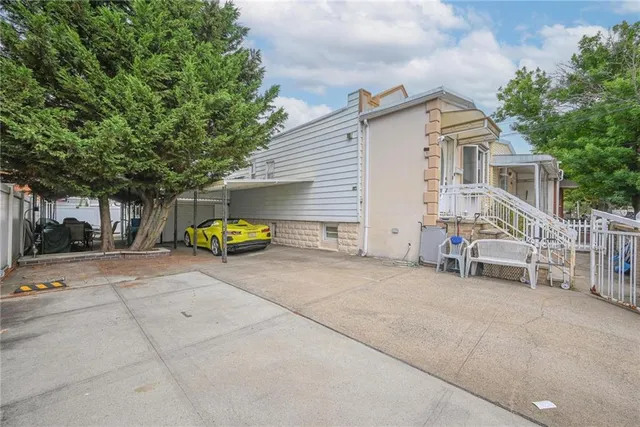 a view of a house with a patio and a yard