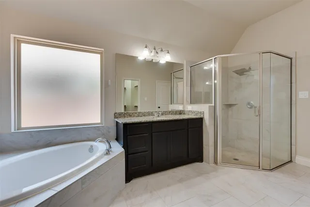 a bathroom with a tub a sink and mirror