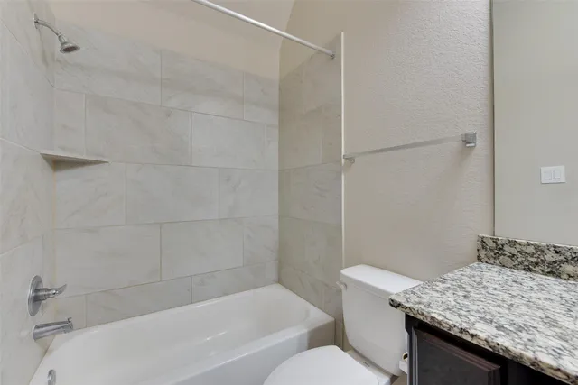 a bathroom with a granite countertop sink toilet and bathtub