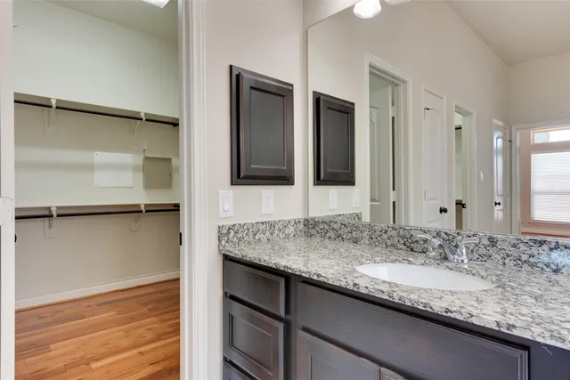 a bathroom with a granite countertop sink and mirror