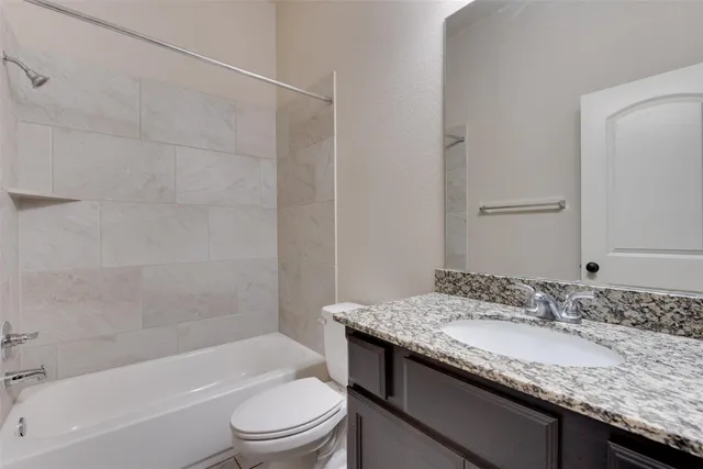 a bathroom with a granite countertop sink a toilet and bathtub