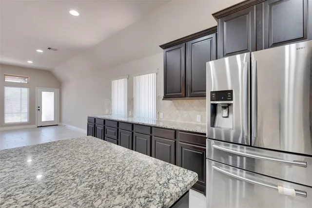 a kitchen with kitchen island a counter top space cabinets and stainless steel appliances