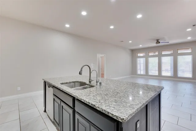 a kitchen with granite countertop sink and natural light