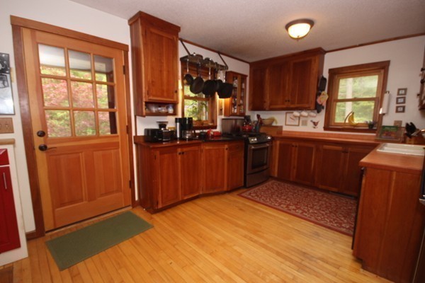 91 Long Hill Road Leverett, MA 01054 - Photo 11 of 29 a kitchen with stainless steel appliances granite countertop wooden cabinets a sink and a large window