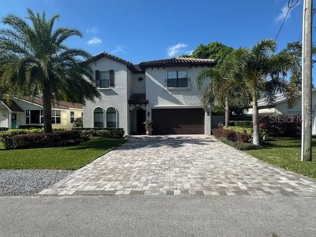 a view of a white house with a yard and potted plants