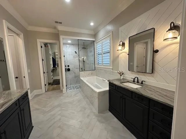 a bathroom with a double vanity sink a mirror and a bathtub