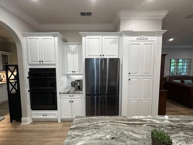 a kitchen with stainless steel appliances kitchen island granite countertop a refrigerator and cabinets