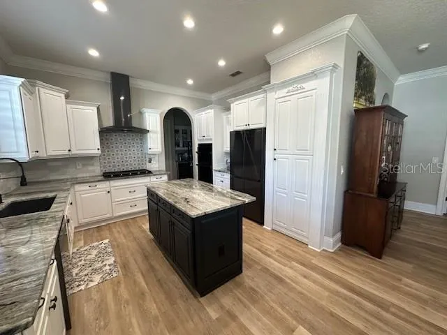 a kitchen with stainless steel appliances granite countertop a refrigerator a stove and a sink