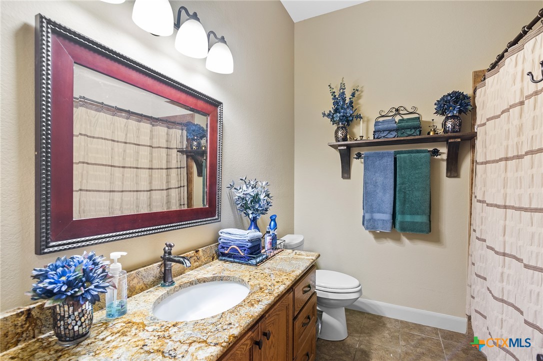 166 Post Oak Bend Inez, TX 77968 - Photo 15 of 48 a bathroom with a granite countertop sink toilet and mirror