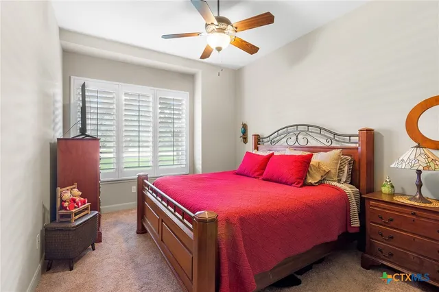 a bedroom with a large bed and a flat tv screen on dresser