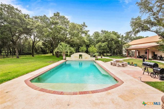 a view of a house with a big yard and large trees