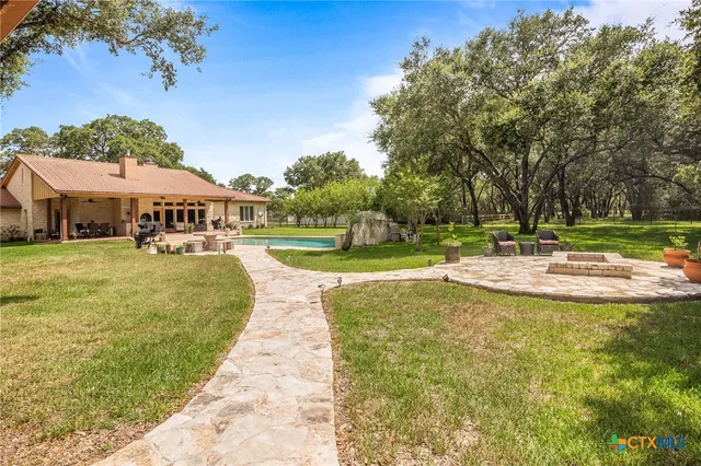 a view of a house with a big yard and a large tree