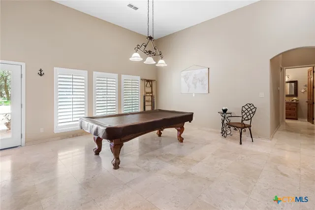 a living room with couches and projector with a kitchen
