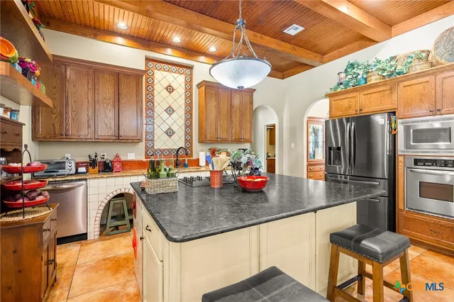 a kitchen with stainless steel appliances granite countertop a stove and cabinets