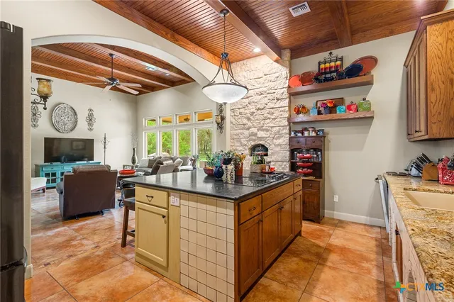 a kitchen with stainless steel appliances granite countertop a sink stove and cabinets