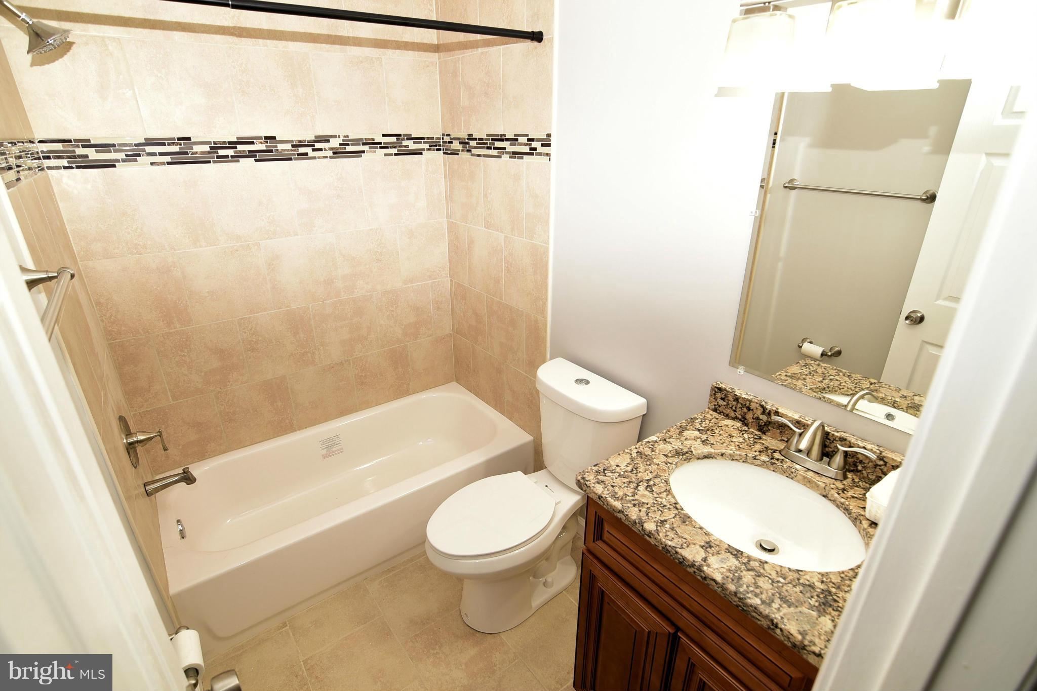 6504 Springbrook Lane Clinton, MD 20735 - Photo 13 of 30 a bathroom with a granite countertop sink toilet and shower