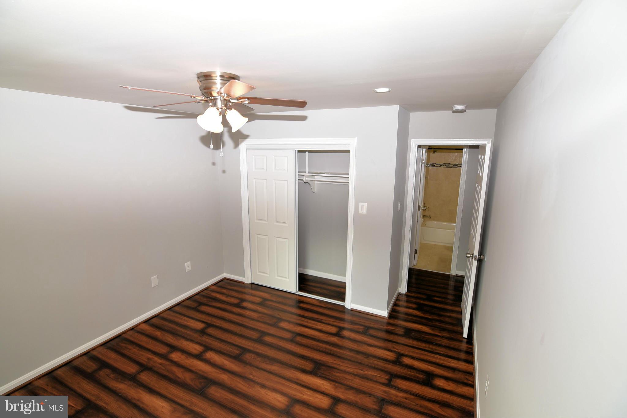 6504 Springbrook Lane Clinton, MD 20735 - Photo 14 of 30 a bedroom with a bed and a chandelier fan