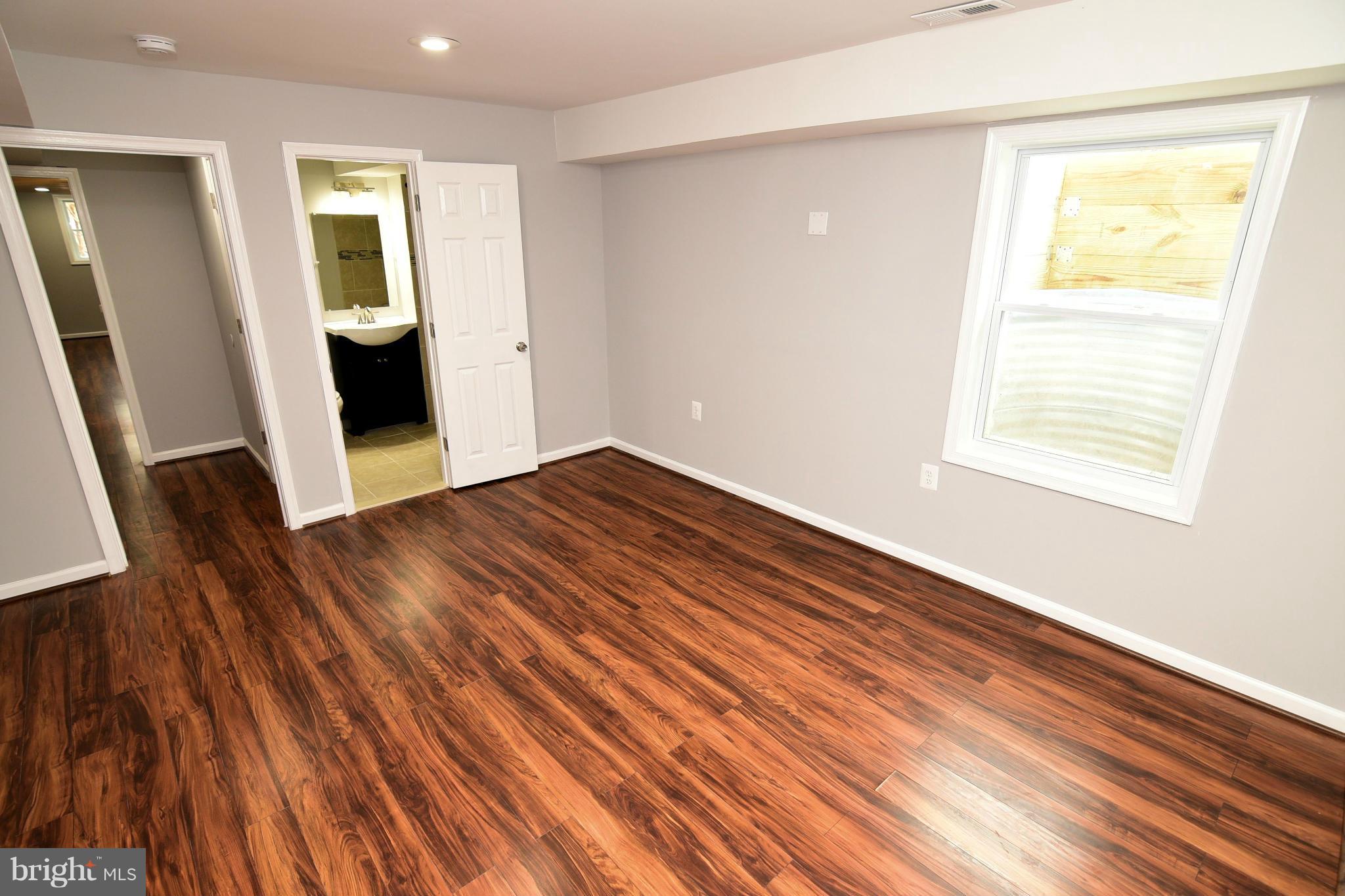 6504 Springbrook Lane Clinton, MD 20735 - Photo 26 of 30 a view of an empty room with wooden floor and a window