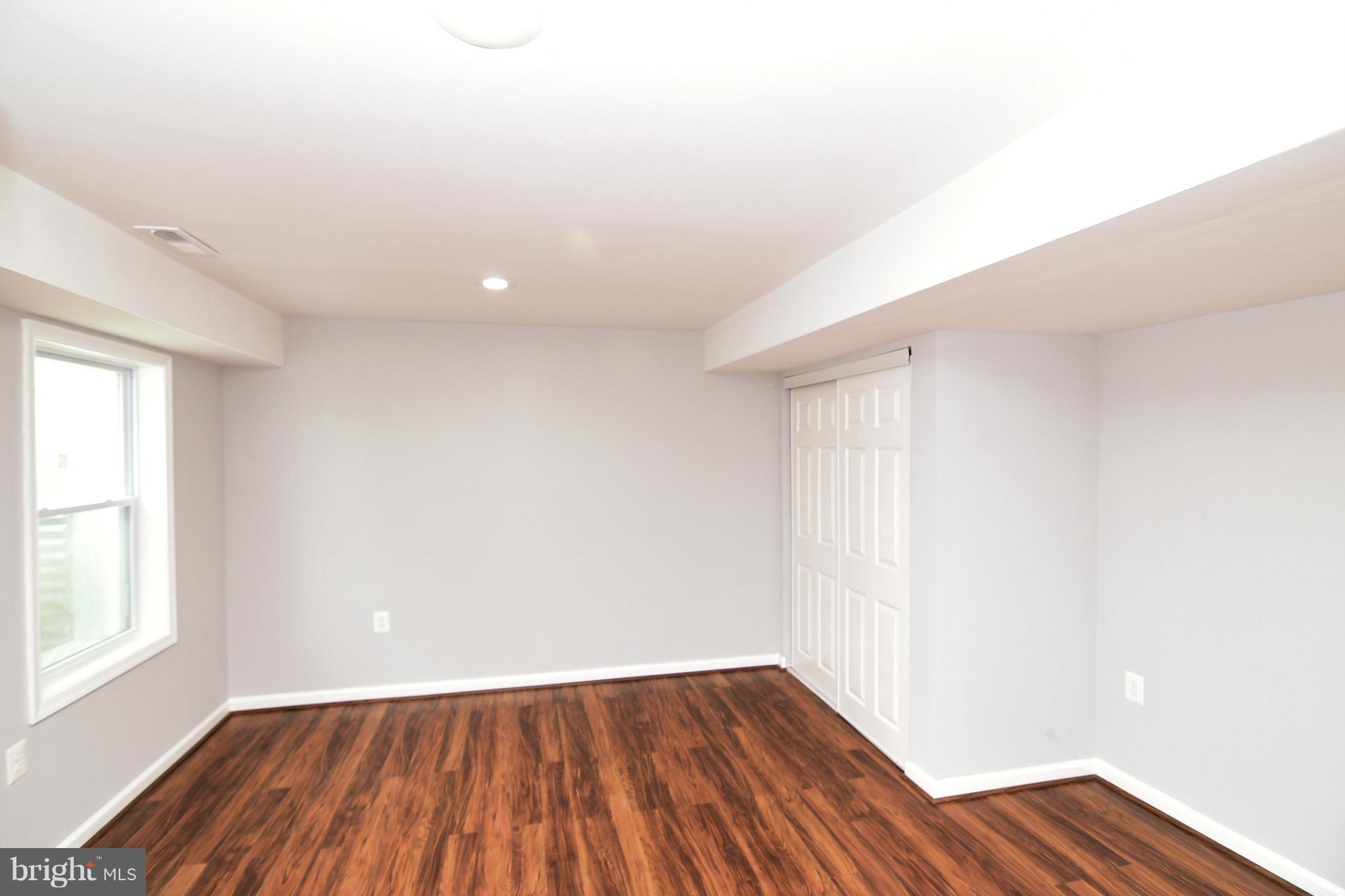 6504 Springbrook Lane Clinton, MD 20735 - Photo 27 of 30 an empty room with wooden floor and windows