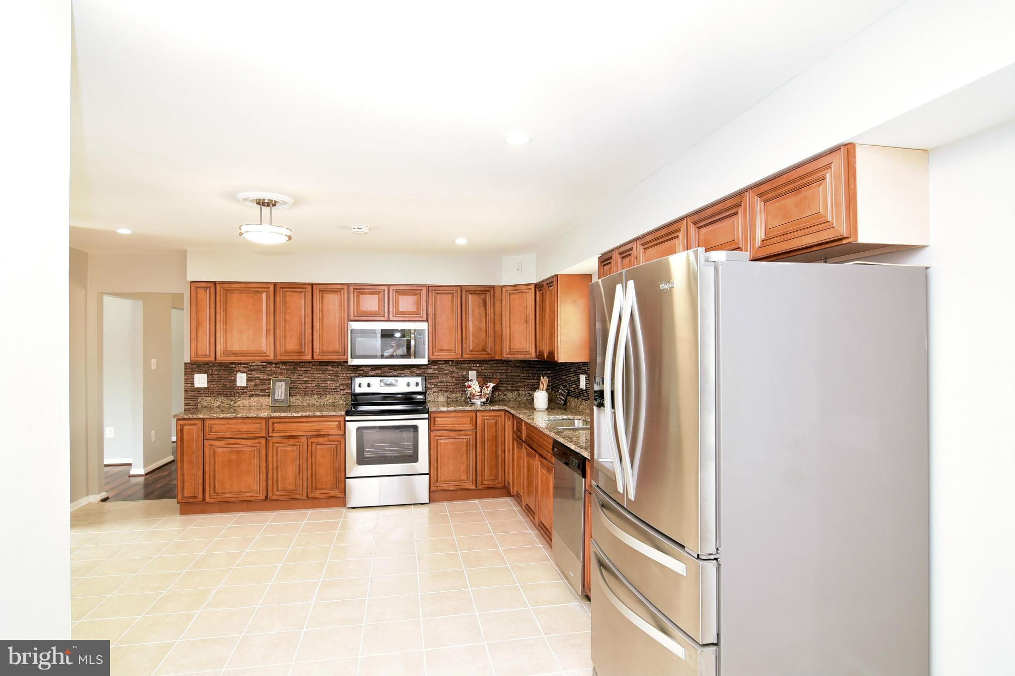 6504 Springbrook Lane Clinton, MD 20735 - Photo 8 of 30 a kitchen with stainless steel appliances granite countertop a refrigerator and a stove