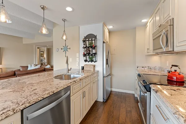 a kitchen with stainless steel appliances granite countertop a sink and stove