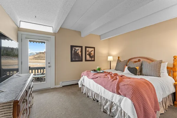 a bedroom with a bed and dresser with mirror