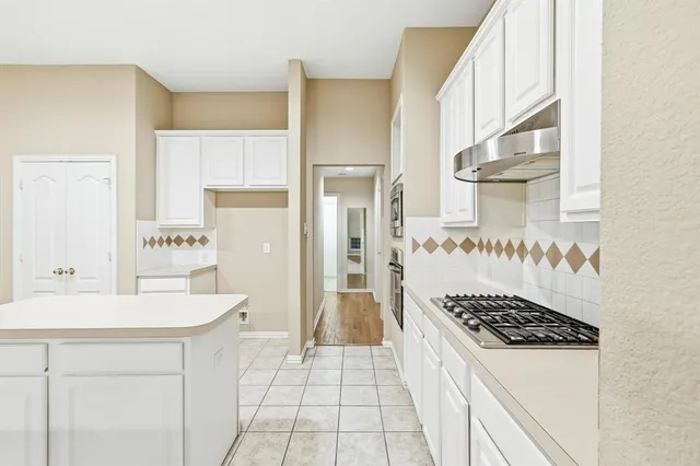 a kitchen with stainless steel appliances granite countertop a sink and a refrigerator