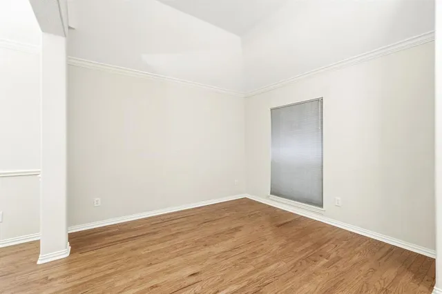 a view of an empty room with wooden floor