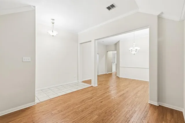 a view of a chandelier in big room and wooden floor