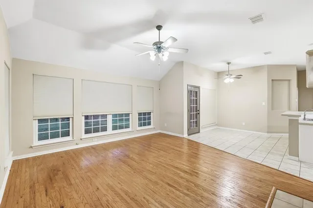 an empty room with wooden floor closet and fan