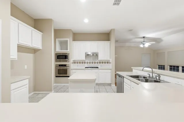 a kitchen with stainless steel appliances kitchen island granite countertop a sink and cabinets