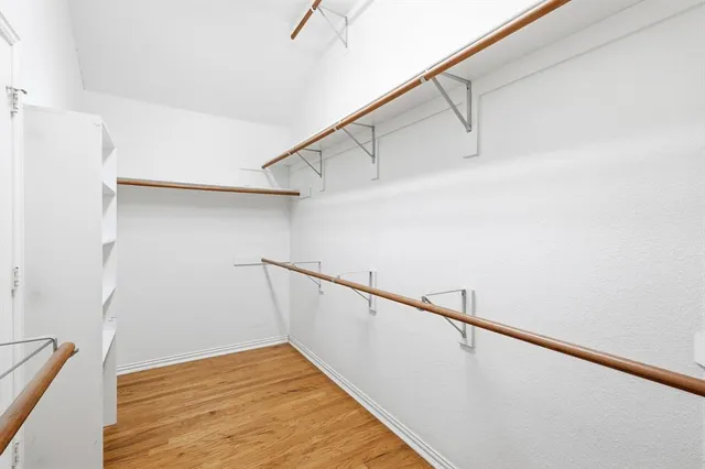 an empty room with a window and a chandelier fan