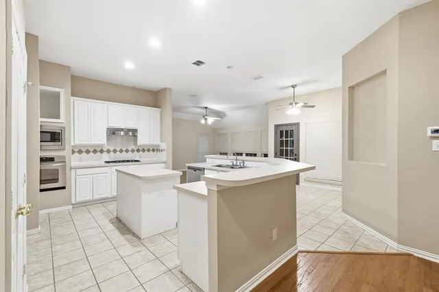 a kitchen with a sink and white cabinets