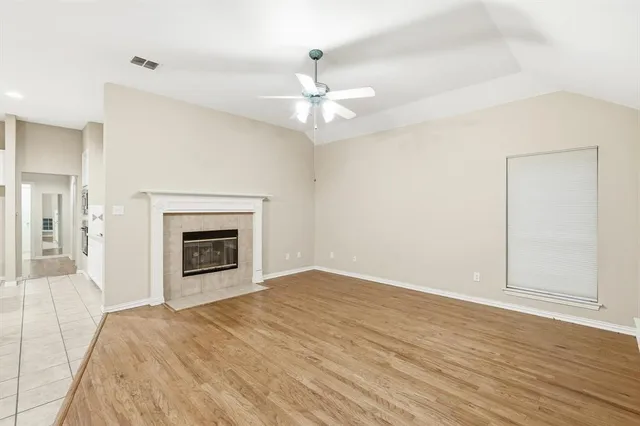 an empty room with fan and fireplace