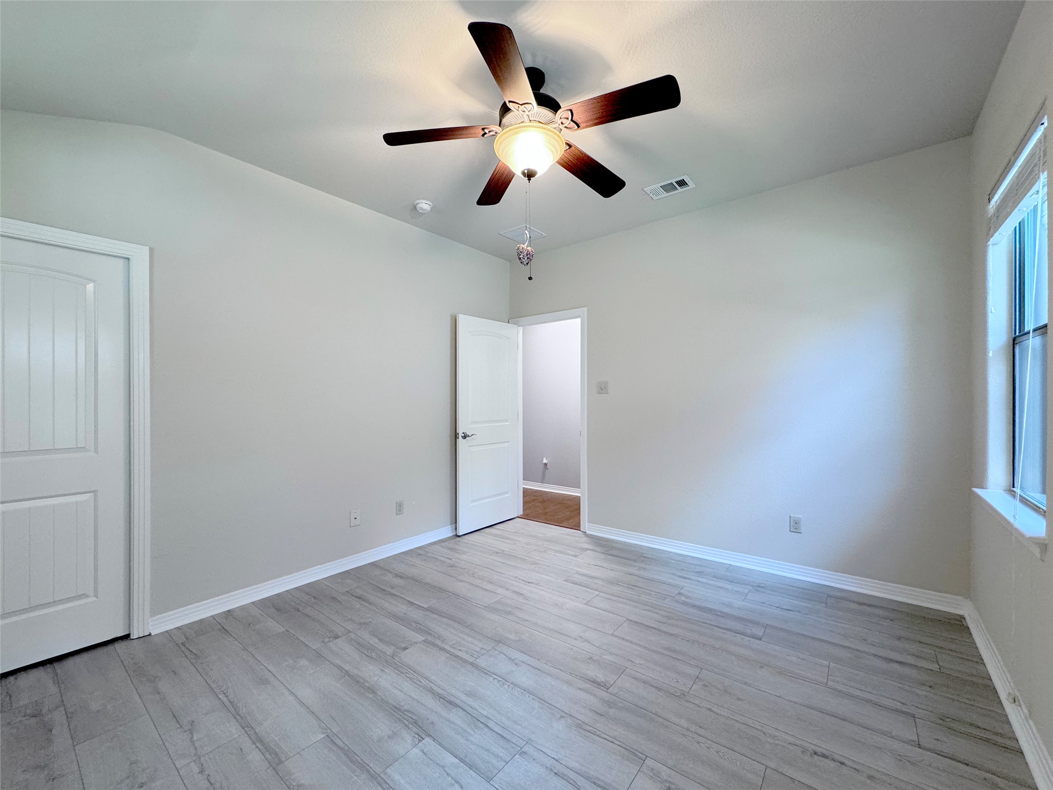 9707 Anderson Mill Road, Unit 21 Austin, TX 78750 - Photo 21 of 27 Crisp white trim and cool-toned plank flooring create a modern backdrop in this inviting bedroom.