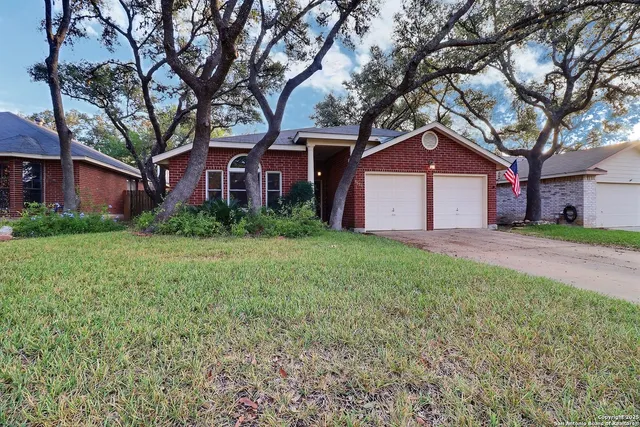 a front view of a house with a garden and trees