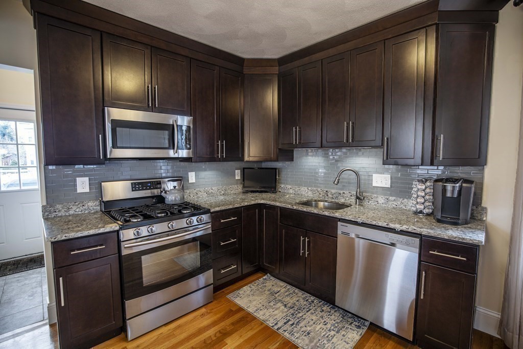 10 Columbus Avenue Saugus, MA 01906 - Photo 14 of 38 a kitchen with granite countertop wooden cabinets stainless steel appliances and a sink