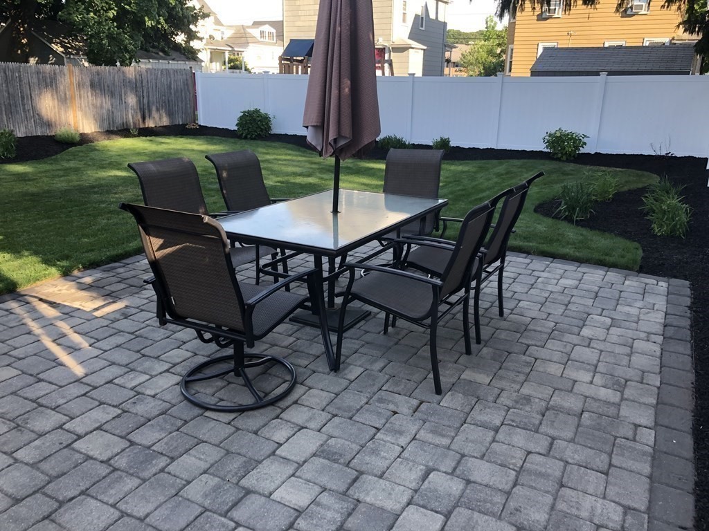 10 Columbus Avenue Saugus, MA 01906 - Photo 33 of 38 a view of a backyard with table and chairs potted plants and wooden fence