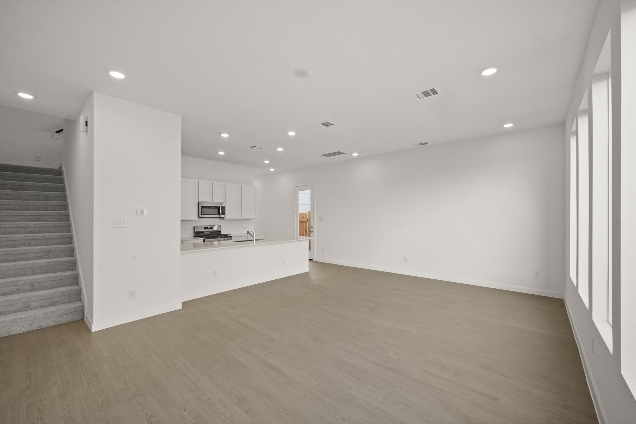 2207 Diagonal Lane Houston, TX 77051 - Photo 21 of 36 an empty room with wooden floor and a kitchen