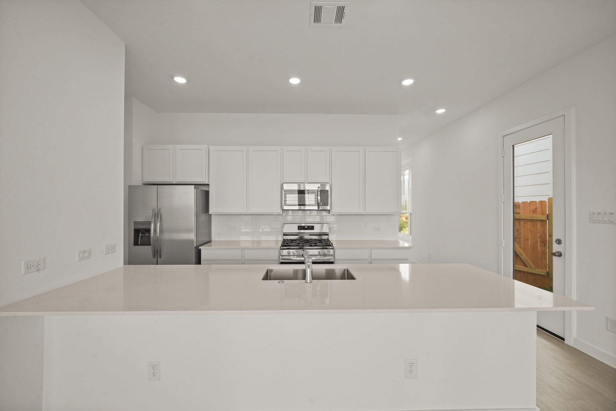 2207 Diagonal Lane Houston, TX 77051 - Photo 28 of 36 a kitchen with kitchen island a sink a stove a refrigerator and white cabinets