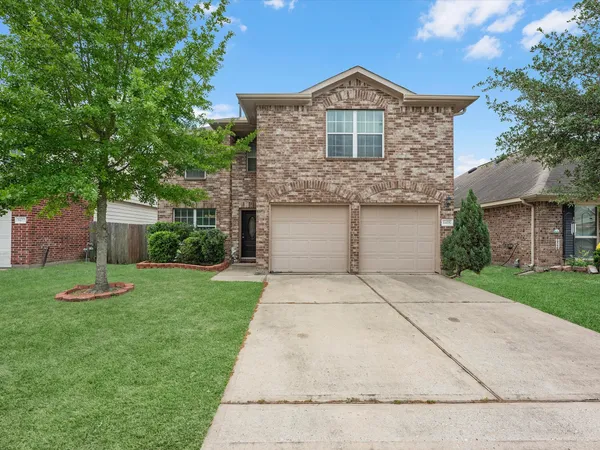 a front view of a house with a yard and a garage