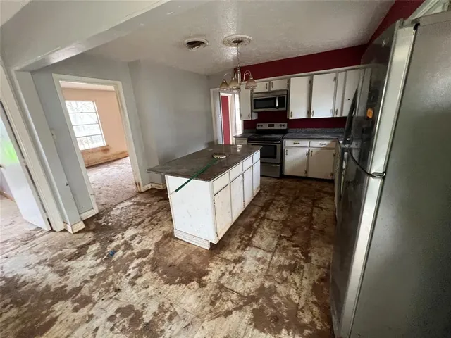 a kitchen with granite countertop a refrigerator and a stove
