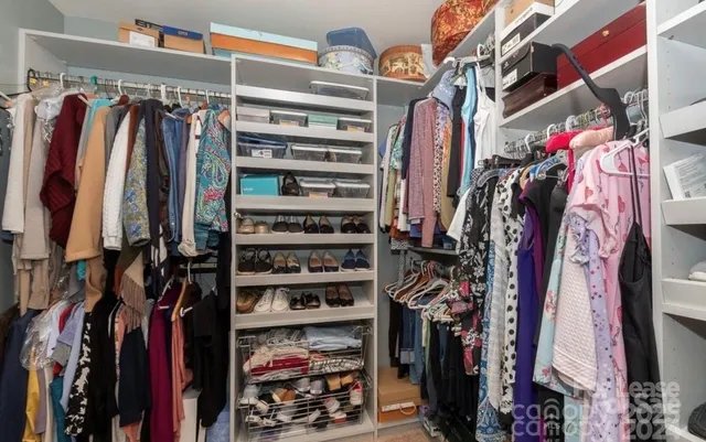 a view of walk in closet with clothes and shoes