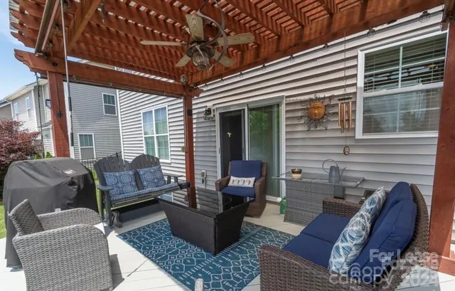 a view of a patio with couches table and chairs and potted plants