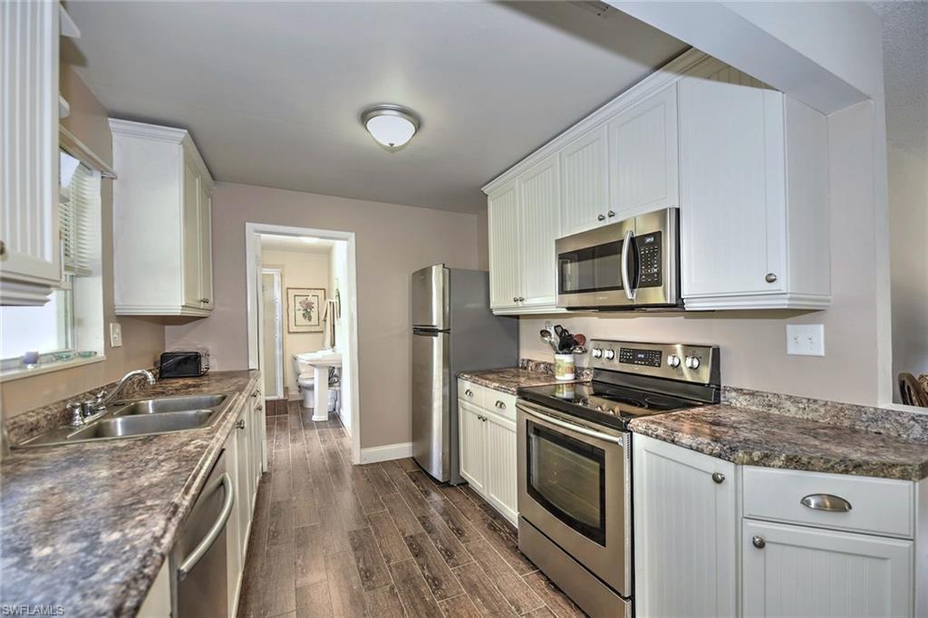 7315 Barragan Road Fort Myers, FL 33967 - Photo 6 of 19 a kitchen with granite countertop a sink a stove top oven and cabinetry
